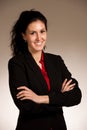 Portrait of young happy smiling woman in business suit standing over gray background Royalty Free Stock Photo