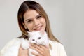 Portrait of young happy smiling woman holding cute white Persian cat, happy beautiful lady playing with fluffy pet, girl hugging Royalty Free Stock Photo