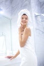 Portrait of young happy smiling woman standing in the bath in white towels wrapped around her head and body after Royalty Free Stock Photo