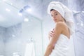 Portrait of young happy smiling woman standing in the bath in white towels wrapped around her head and body after Royalty Free Stock Photo