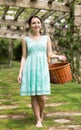 portrait of young woman holding a basket near roses in a garden Royalty Free Stock Photo