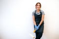 Portrait of young happy woman in apron painting walls with a roller in a new house Royalty Free Stock Photo