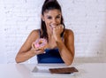 Portrait of young happy woman eating delighted chocolate bar and donuts Royalty Free Stock Photo