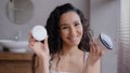 Portrait young happy woman standing in bathroom looking at camera smiling making choice in favor of skin care cream with Royalty Free Stock Photo