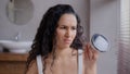 Portrait young happy woman standing in bathroom looking at camera smiling making choice in favor of skin care cream with Royalty Free Stock Photo