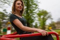 Portrait of a young happy woman of thirty plus years old riding a carousel. Motion blur. Copy space Royalty Free Stock Photo