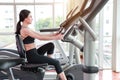 Portrait of young healthy and sporty woman bicycling on exercise machine in gym Royalty Free Stock Photo