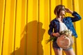 Portrait of hipster girl wearing glasses and hat with flowers against yellow background. Summer outfit. Fashion. Space. Royalty Free Stock Photo