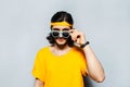 Portrait of young hipster wearing sunglasses and yellow shirt on grey background. Royalty Free Stock Photo