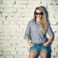 Portrait of Young Hipster Woman at the Brick Wall