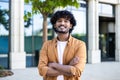 Portrait of young hispanic freelancer businessman outside office building, successful man looking at camera and smiling Royalty Free Stock Photo