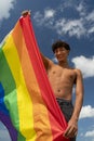 Portrait of young Hispanic gay boy looking at camera, holding LGBT flag - Focus on face vertical imagin Royalty Free Stock Photo