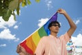 Portrait of young Hispanic gay boy looking at camera, holding LGBT flag - Focus on face landscape imagin Royalty Free Stock Photo