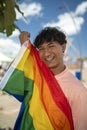 Portrait of young Hispanic gay boy looking at camera, holding LGBT flag - Focus on face vertical imagin Royalty Free Stock Photo