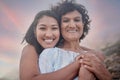 Portrait of a young hispanic woman spending the day at the beach with her elderly mother. Mixed race female and her Royalty Free Stock Photo