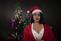 Portrait of young and attractive Indian Bengali brunette woman in red and white Santa Clause lingerie in Christmas.
