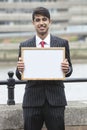 Portrait of young Indian businessman holding blank sign Royalty Free Stock Photo