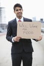 Portrait of young Indian businessman holding 'Will Work for Food' sign Royalty Free Stock Photo