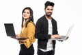 Portrait of a young indian couple holding laptops computer while standing isolated over gray wall background Royalty Free Stock Photo