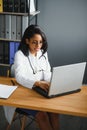 Portrait of young indian doctor working in the hospital while looking at laptop and write on clipboard. Royalty Free Stock Photo