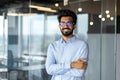 Portrait of a young Indian male designer, engineer, architect who is wearing glasses and a blue shirt smiling standing Royalty Free Stock Photo