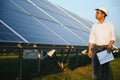 Portrait of a young Indian male engineer or architect at a solar panel farm. The concept of clean energy Royalty Free Stock Photo