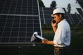 Portrait of a young Indian male engineer or architect at a solar panel farm. The concept of clean energy Royalty Free Stock Photo