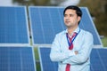 Portrait young indian technician or manager wearing formal cloths standing with solar panel. renewable energy, man standing