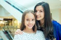 Portrait of a young indian woman wearing blue sari and gold bracelet having fun with her cute daughter in shopping mall Royalty Free Stock Photo