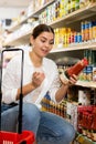 Young girl reading labels on bottles with juices in store Royalty Free Stock Photo