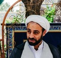 Portrait of a young Iranian Mullah wearing a keffiyeh in the courtyard of Jame Mosque