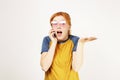 Beautiful red headed young woman posing, showing emotional facial expressions and making funny faces with mobile phone