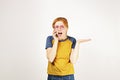 Beautiful red headed young woman posing, showing emotional facial expressions and making funny faces with mobile phone