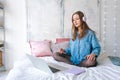 Portrait young joyful woman in home clothes, at laptop studying online or Royalty Free Stock Photo