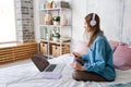 Portrait young joyful woman in home clothes, at laptop studying online or Royalty Free Stock Photo