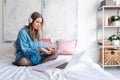 Portrait young joyful woman in home clothes, at laptop studying online or Royalty Free Stock Photo