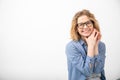 Portrait of young joyous attractive woman sit looking at camera, folding hands near face on white background. Emotions.