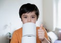 Portrait Young Kid carrying a stack of toilet paper with blurry living room background, Selective focus Child boy holding toilet Royalty Free Stock Photo