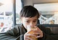 Portrait Young kid drinking fresh orange juice for breakfast in cafe, Happy child boy drinking glass of fruit juice while waiting Royalty Free Stock Photo