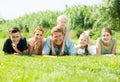 Portrait of young large family lying on green lawn outdoors