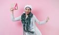 Portrait of young latin woman holding a present box with copy space in a christmas concept on pink background Royalty Free Stock Photo