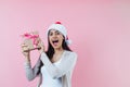 Portrait of young latin woman holding a present box with copy space in a christmas concept on pink background Royalty Free Stock Photo