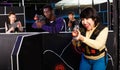 Portrait of young Latin woman with laser gun having fun on dark lasertag arena with multinational team