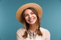 Portrait of a young laughing girl in summer hat isolated over blue background Royalty Free Stock Photo