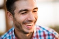 Portrait of young laughing man with dark hair in shirt on blurred background. Royalty Free Stock Photo