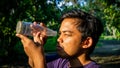 Portrait of young Malay man seeing inside a glass bottle which act as binocular