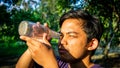 Portrait of young Malay man seeing inside a glass bottle which act as binocular