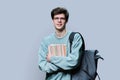 Portrait of young male college student in glasses with backpack on gray background Royalty Free Stock Photo