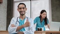 Portrait of young male doctor thumb up, female partner behind Royalty Free Stock Photo