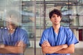 Portrait Of Young Male Doctor Wearing Scrubs Standing In Modern Hospital Building Royalty Free Stock Photo